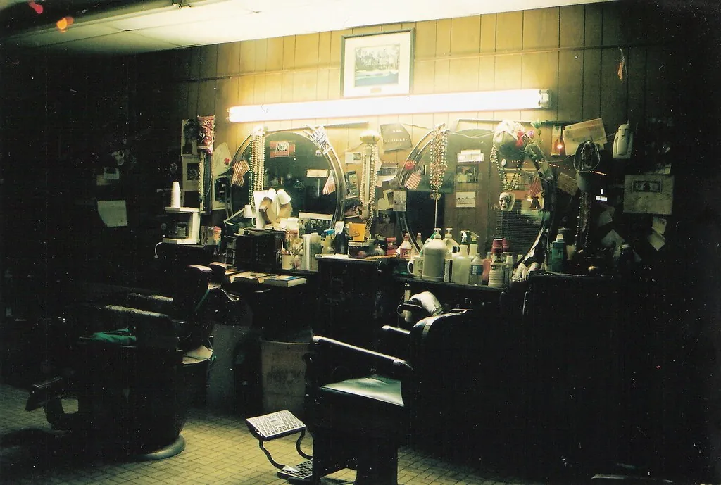 Barbería clásica en penumbra con sillones listos